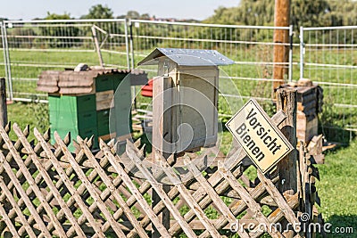 Beehive and insect hotel with a sign in German language - Caution bees, Germany Stock Photo
