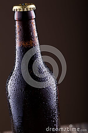 Beer bottle with water drops ongrey background. Stock Photo