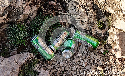 Beer cans by the rocks on the beach Editorial Stock Photo