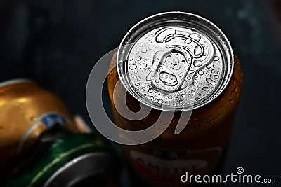 Beer cans. Wet crumpled and full beer cans with condensation drops on a dark background, top view. AMSTEL is a world famous brand Editorial Stock Photo