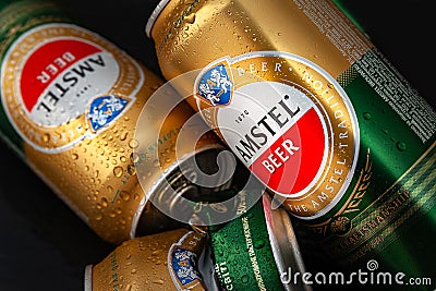 Beer cans. Wet crumpled and full beer cans with condensation drops on a dark background, top view. AMSTEL world famous brand in Editorial Stock Photo