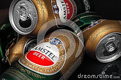 Beer cans. Wet crumpled and full beer cans with water drops on a dark background, top view. AMSTEL is a world famous brand from Editorial Stock Photo
