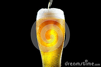 Beer. Cold Craft light Beer pouring in a glass with water drops. Pint of Ale Beer close up isolated on black background, closeup Stock Photo