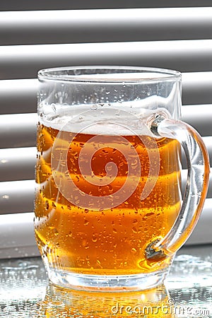 Beer glass blinds sunlight E Stock Photo