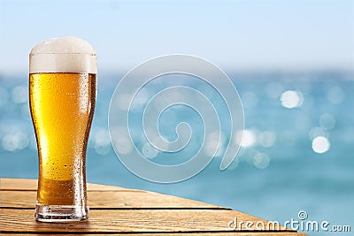 Beer glass on a blurred background of the sea. Stock Photo