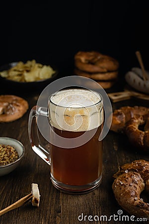 Beer glass with pretzels, bratwurst and snacks on rustic wooden table Stock Photo