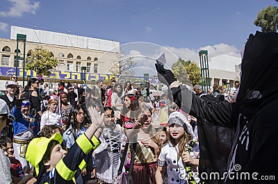Beer-Sheva, ISRAEL - March 5, 2015: Children in carnival costumes catch the gifts on the Feast of Purim Editorial Stock Photo