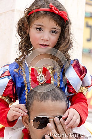 Beer-Sheva, ISRAEL - March 5, 2015: Girl dressed as Snow White Disney cartoon with a red bow on the shoulders of his father-Purim Editorial Stock Photo