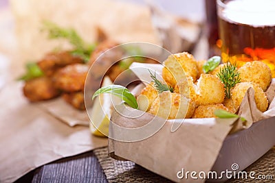 Beer snacks. Fried fried fish and cheese balls with lemon and greens. Stock Photo