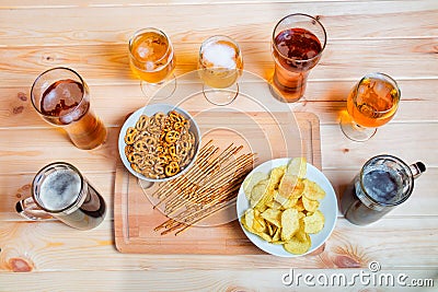 Beer on wooden table. Beer snacks are chips, salted straws and pretzels Stock Photo