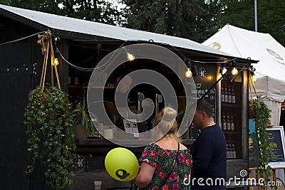 Riga, Latvia - May 24 2019: Couple purchasing delicious beer from bartender Editorial Stock Photo