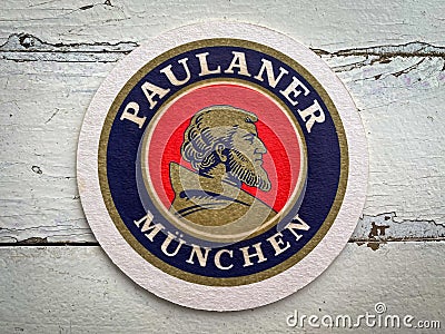 A Beermat of German beer Paulaner on the table. Editorial Stock Photo