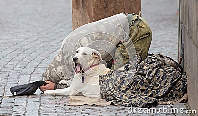 Beggar with dog begging for alms on the street in Prague Editorial Stock Photo