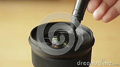 Beginning photographer or video cameraman is carefully cleaning the front glass of the lens. Stock Photo