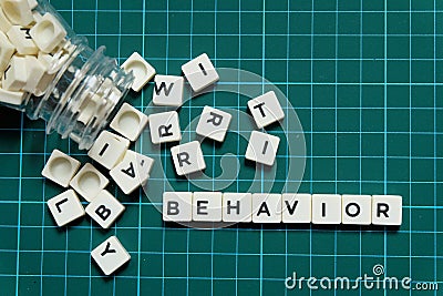 Behavior word made of square letter word on green square mat background. Stock Photo