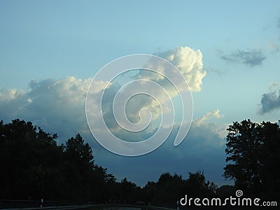 Behind this big cloud of rain and storm, the sun seems to want to return Stock Photo