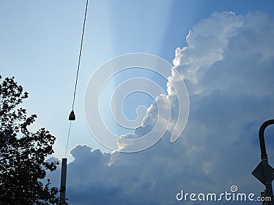 Behind this big cloud of rain and storm, the sun seems to want to return Stock Photo