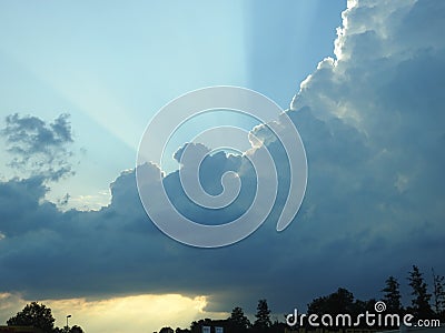 Behind this big cloud of rain and storm, the sun seems to want to return Stock Photo