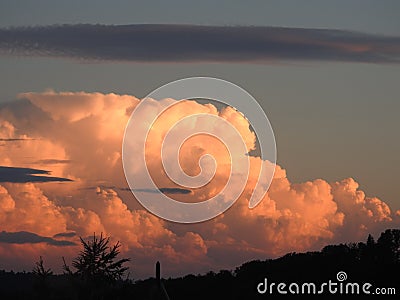 Behind this big cloud of rain and storm, the sun seems to want to return Stock Photo