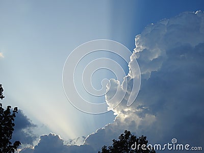 Behind this big cloud of rain and storm, the sun seems to want to return Stock Photo