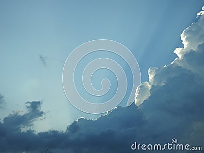 Behind this big cloud of rain and storm, the sun seems to want to return Stock Photo