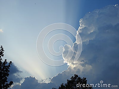 Behind this big cloud of rain and storm, the sun seems to want to return Stock Photo