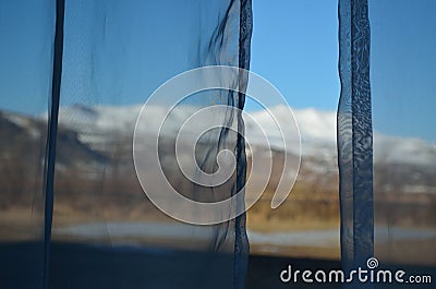 Behind the curtains. A hazy hint of a lovely view. Stock Photo