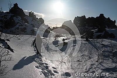Behind shot of the person in the fields full of rocks covered in snow in Iceland Stock Photo
