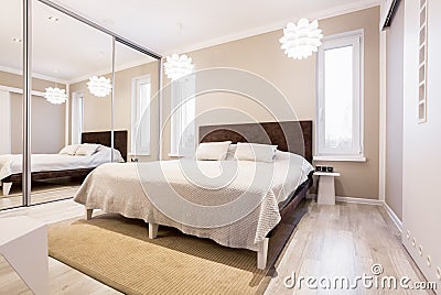 Beige bedroom with mirror wardrobe Stock Photo