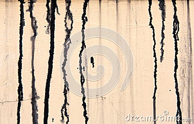 Beige concrete wall with black paint drips, abstract background Stock Photo