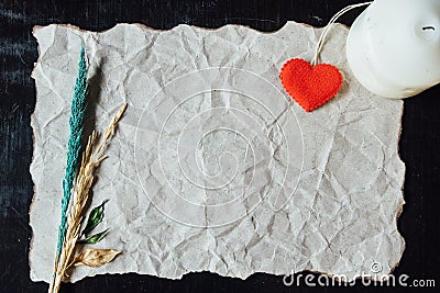 Beige crumpled paper with heart, candle and withered flower for Stock Photo