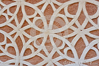 Beige finishing on red rough wall outside in Segovia, Spain. Arabic motif, oriental ornate Stock Photo