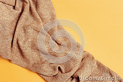 Beige knitted fabric on yellow paper. Autumn shades of pastel tones Stock Photo