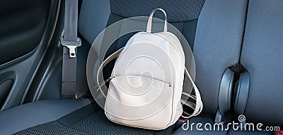 Beige leather backpack on a grey backseat of a car Editorial Stock Photo