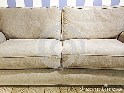 Beige sofa near the wall with striped wallpaper Stock Photo