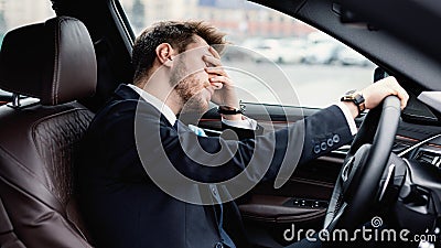 Sad young businessman driving alone in his new car Stock Photo