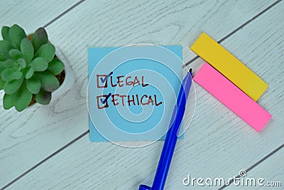 Being Legal and Ethical write on sticky notes isolated on Wooden Table Stock Photo