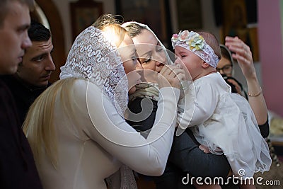 Belarus, Gomel, 25 March. 2018. The Prudhkovsky Church.Mother and godmother on a baptismal rite.Parents with a child in the church Editorial Stock Photo