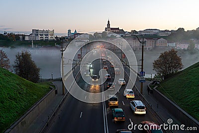 Belarus, Grodno July 15, 2022: The movement of cars and public transport on the bridge over the river. Thick morning fog over the Editorial Stock Photo