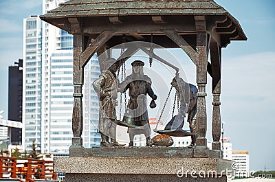 Belarus. Minsk. Monument City scales. Three townspeople who weigh the goods. May 21, 2017 Editorial Stock Photo