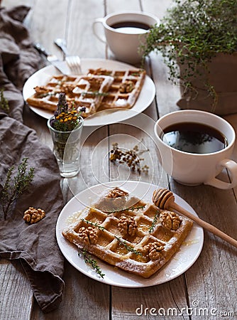 Belgian waffles sweet healthy dessert with honey, nuts, coffee, herbs. Stock Photo