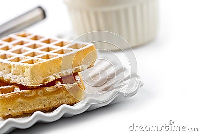 Belgium waffers with sugar powder on ceramic plate and strainer on white table Stock Photo