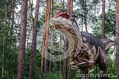 Full-size statue of allosaurus in the forest. Dinopark of Belgorod city Editorial Stock Photo