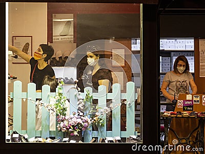 Clients and female staff of a footwear shoes shop wearing a respiratory face mask in Belgrade Editorial Stock Photo