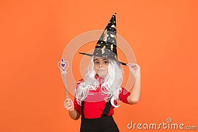 Believe in miracles. happy halloween. smiling child in witch hat. kid hold magic wand. childhood happiness. girl ready Stock Photo
