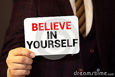 Believe In Yourself, written on an yellow sticky note on a cork bulletin board Stock Photo