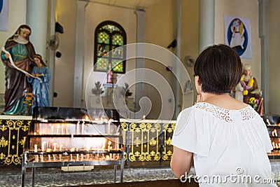 Believer kneel and praying in a Catholic church Stock Photo