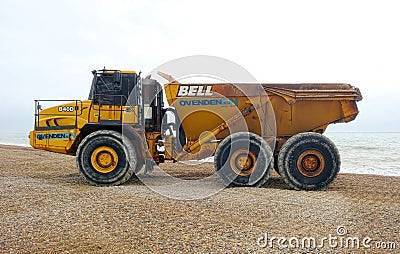 Articulated dump truck. The Bell B40D on pebbled beach. Editorial Stock Photo