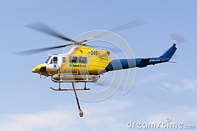 Bell 412 helicopter taking off after filling with a load of water to fight a fire Editorial Stock Photo