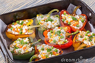 Bell pepper stuffed with rice, green peas, carrots, top view Stock Photo